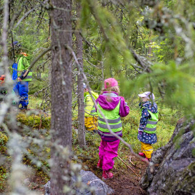 Lapset leikkivät metsässä.