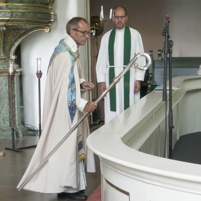 Biskop Björn Vikström lägger ned biskopsstaven vid altaret i Borgå domkyrka