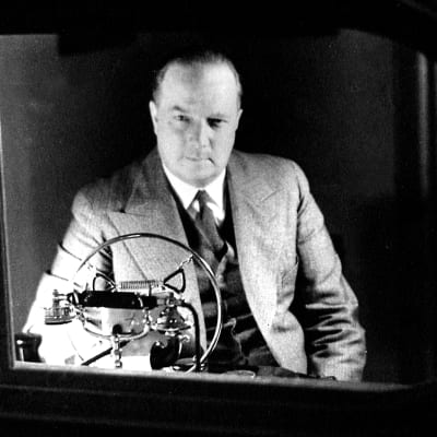 Markus Rautio istuu Yleisradion studiossa lasi-ikkunan takana (1938).