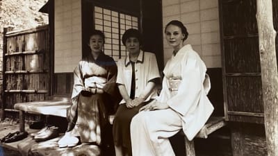 Kolme naista istuu teehuoneen edustalla Japanissa. Kahdella heistä on kimono yllään. 
