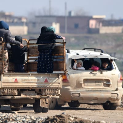 Syyrialaisia pakolaisia autojen kyydissä Aleppon alueella.