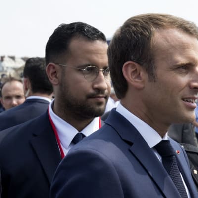 French President Emmanuel Macron (R) walks in front of his aide Alexandre Benalla (L) at the end of the Bastille Day military parade in Paris