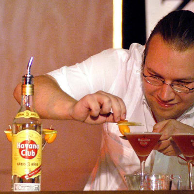 Baranställd tillreder romcocktails vid en drinktävling i Havanna, Kuba år 2004.