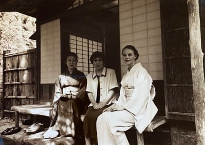 Kolme naista istuu teehuoneen edustalla Japanissa. Kahdella heistä on kimono yllään. 