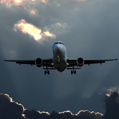 Ett flygplan uppe i luften bland mörka moln.