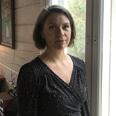Anna Rajamäki seisoo ikkunan edessä