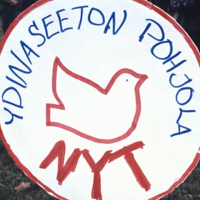 Ydinaseeton pohjola-kyltti ja pieni tyttö sen vieressä.