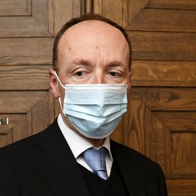 Jussi Halla-aho med munskydd framför riksdagsuppens mötsrum i riksdagen.