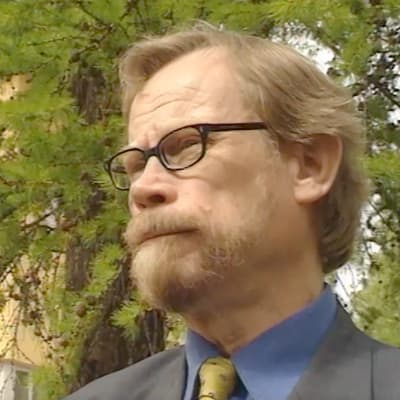 Vihreiden kansanedustaja Erkki Pulliainen vastaamassa toimittajien kysymyksiin.