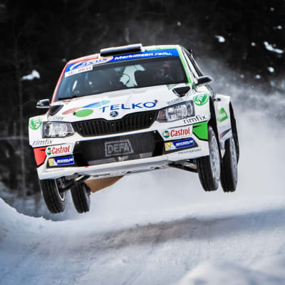 Rallybil hoppar långt i en backe.