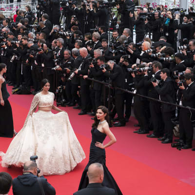 Festivaalivieraita Cannesin festivaalipalatsin punaisella matolla.