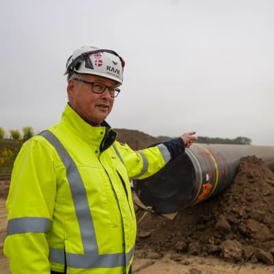 Søren Juul Larsen pekar på en gasledning som inte grävts ner ännu.