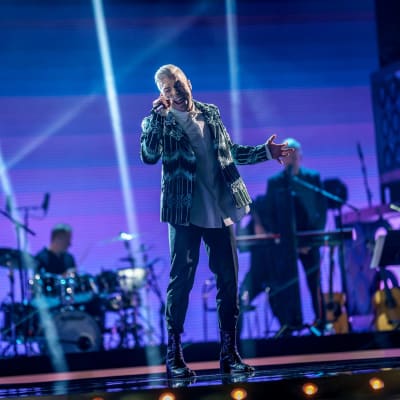 Antti Tuisku esiintyy tummissa vaatteissa SuomiLOVE-lavalla. 
