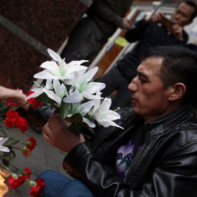 Rysk man placerar blommor efter terrorattacken i S:t Petersburg den 3 april.