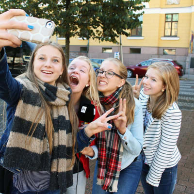 Kuvassa nuoret ottavat älypuhelimella kuvaa itsestään.