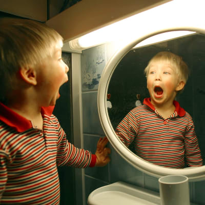 En pojke ser sig själv i spegeln