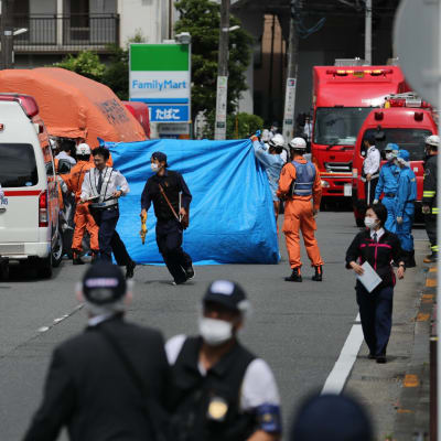 Räddningspersonal på den gata i Kawasaki där tisdagens knivattack inträffade. 