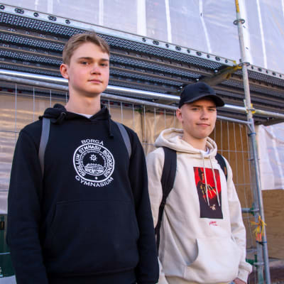 En bild på två elever från Borgå Gymnasium som tittar mot kameran. De står utanför Borgå Gymnasium.