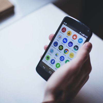 Mobiltelefon  i handen ljus bakgrund