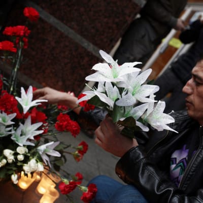 Rysk man placerar blommor efter terrorattacken i S:t Petersburg den 3 april.