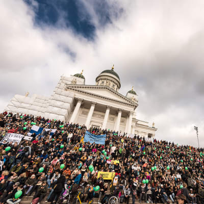 Demonstranter på trapporna vid Domkyrkan i Helsingfors.
