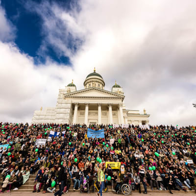 Demnstranter på trapporna vid Domkyrkan i Helsingfors.
