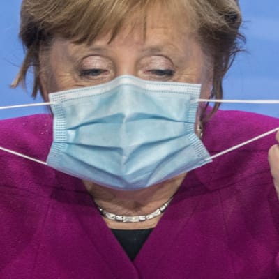 Förbundskansler Angela Merkel tar bort sitt munskydd för att hålla presskonferens 14.10.2020.