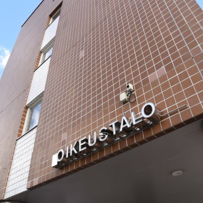 Oulun oikeustalon tiiliseinä ja taustalla kesäinen taivas.