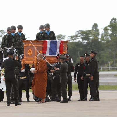 Buddhalainen munkki ja armeijan kunniavartiosto saattoivat kuolleen sukeltajan arkkua Chiang Rain lentokentällä.