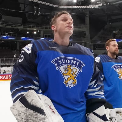 Finländska hockeyspelare står uppställda på blålinjen utan hjälmar på huvudet.