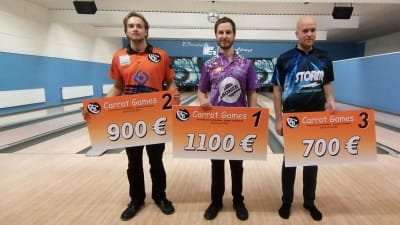 Tre män står med prisplakat i händerna.