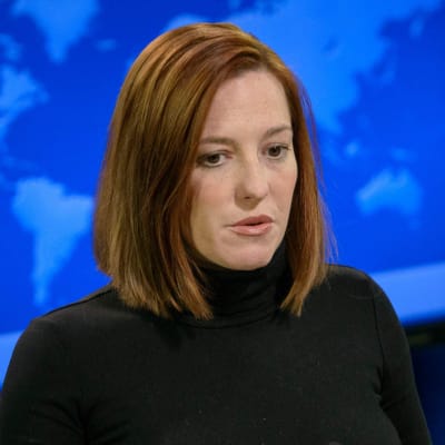 Jen Psaki står vid ett talarpodium och pratar.