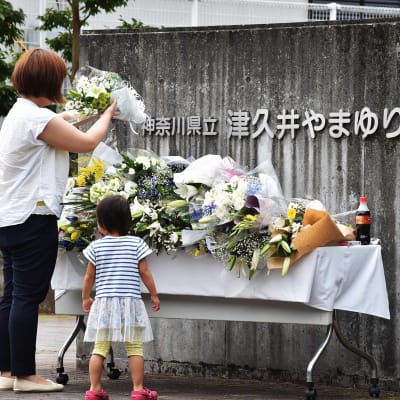 Äiti ja tytär tuovat kukkia puukotuksen uhreille Japanilla heinäkuussa 2016.