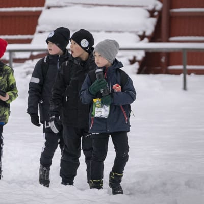 Lapset katsovat jalkapallopelia Oulunkylän urheilukentällä