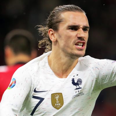Antoine Griezmann pekar framåt med ena handen.