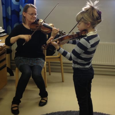 elev övar violinspelande med sin lärare