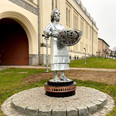 Staty föreställande en kvinna som håller i en korg.