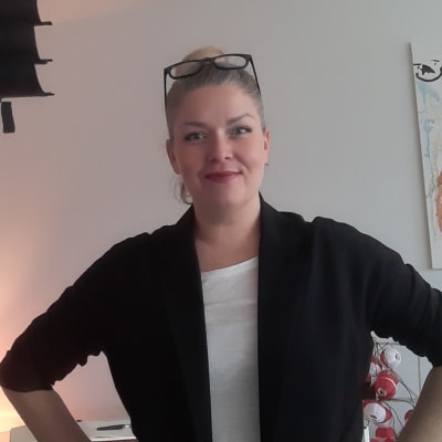 en kvinna som står inomus i ett vitt vardagsrum