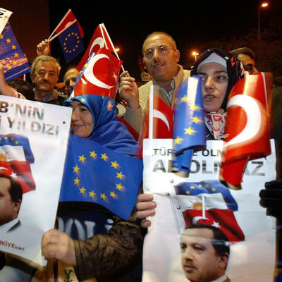 Ihmisiä heiluttelemassa pääministeri Erdoganin kuvia ja EU-lippuja.