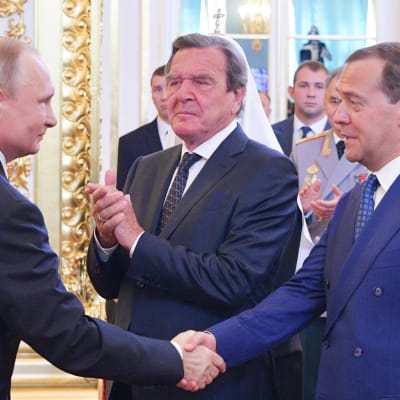Vladimir Putin kättelee  Dmitri Medvedeviä.