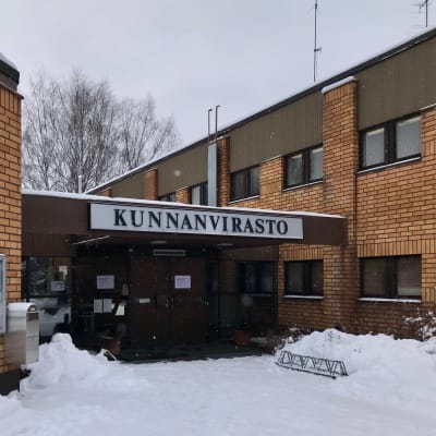 Hausjärven kunnanviraston pääovi talvella, lunta oven vierustoilla. 