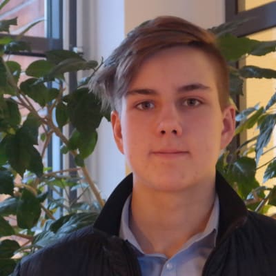 Richard Simola står framför en stor grön växt