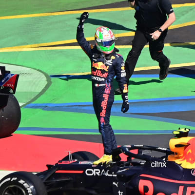 Max Verstappen firar segern bredvid sin bil.