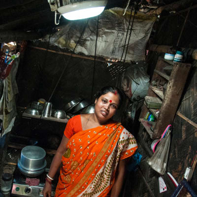 Nainen seisoo aurinkokupulampun alla keittiössä