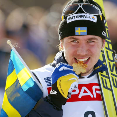 Svenske ex-längdåkarstjärnan Per Elofsson biter på en guldmedalj.
