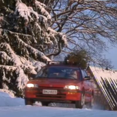 Auto ajaa lumisellä tiellä