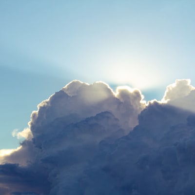 Ett mjukt moln med starka konturer täcker solen. Strålarna tar sig förbi molnets kant.