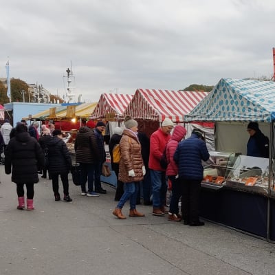 Ihmisiä Turun silakkamarkkinoiden kojuilla.