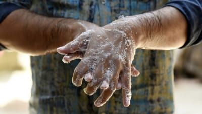 Händer som tvättas med tvål.