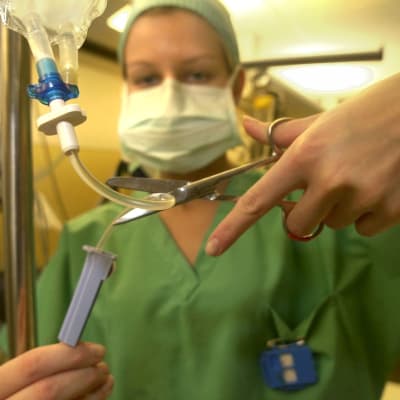 En sjukskötare klipper en tub.